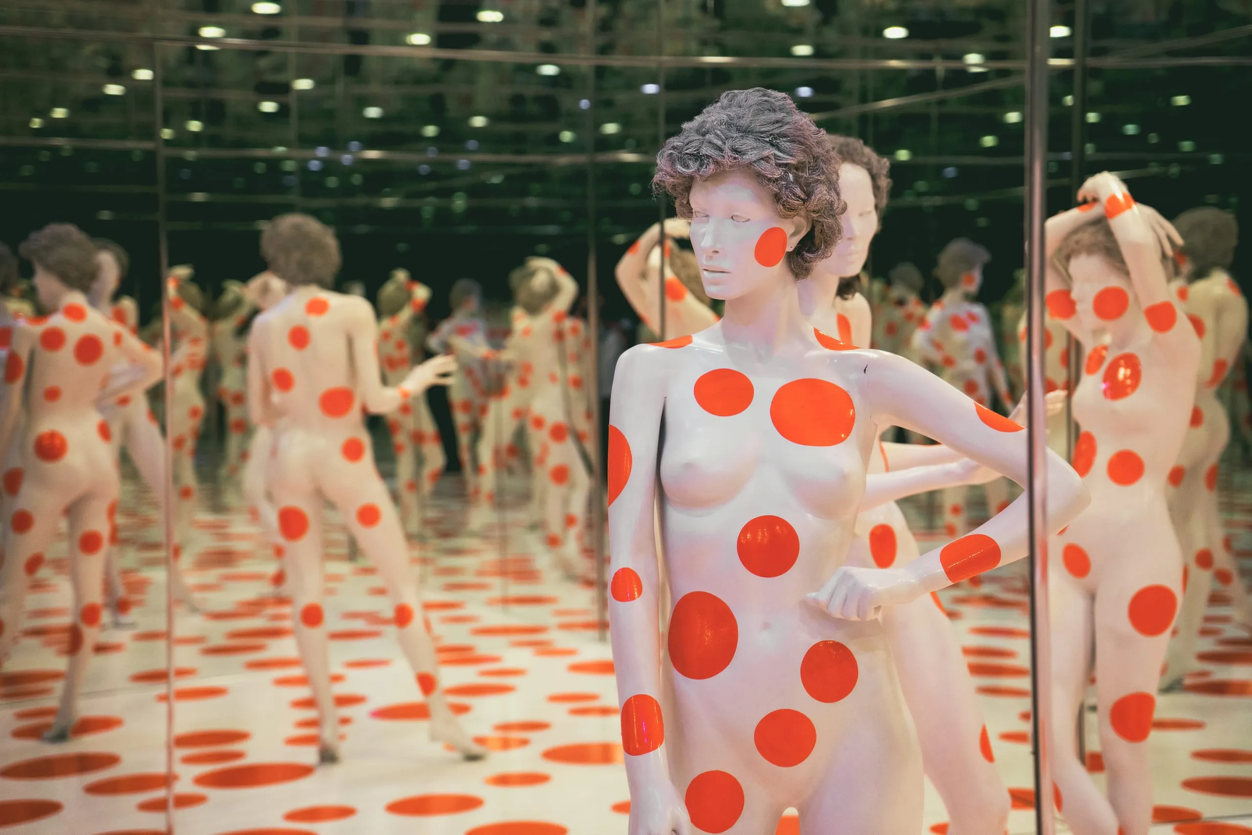 A red-and-white polka-dot mannequin stands in a mirrored infinity room repeating endlessly at a Pittsburgh art installation.