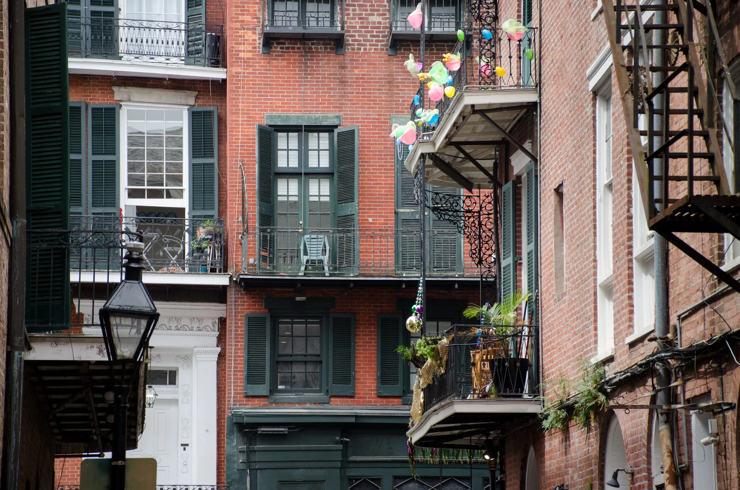 Weathered brick balconies with hanging gas lanterns in the French Quarter