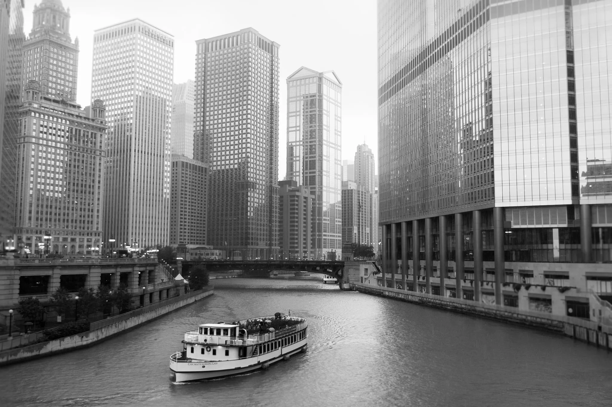 Black and white view down the Chicago River between towering buildings