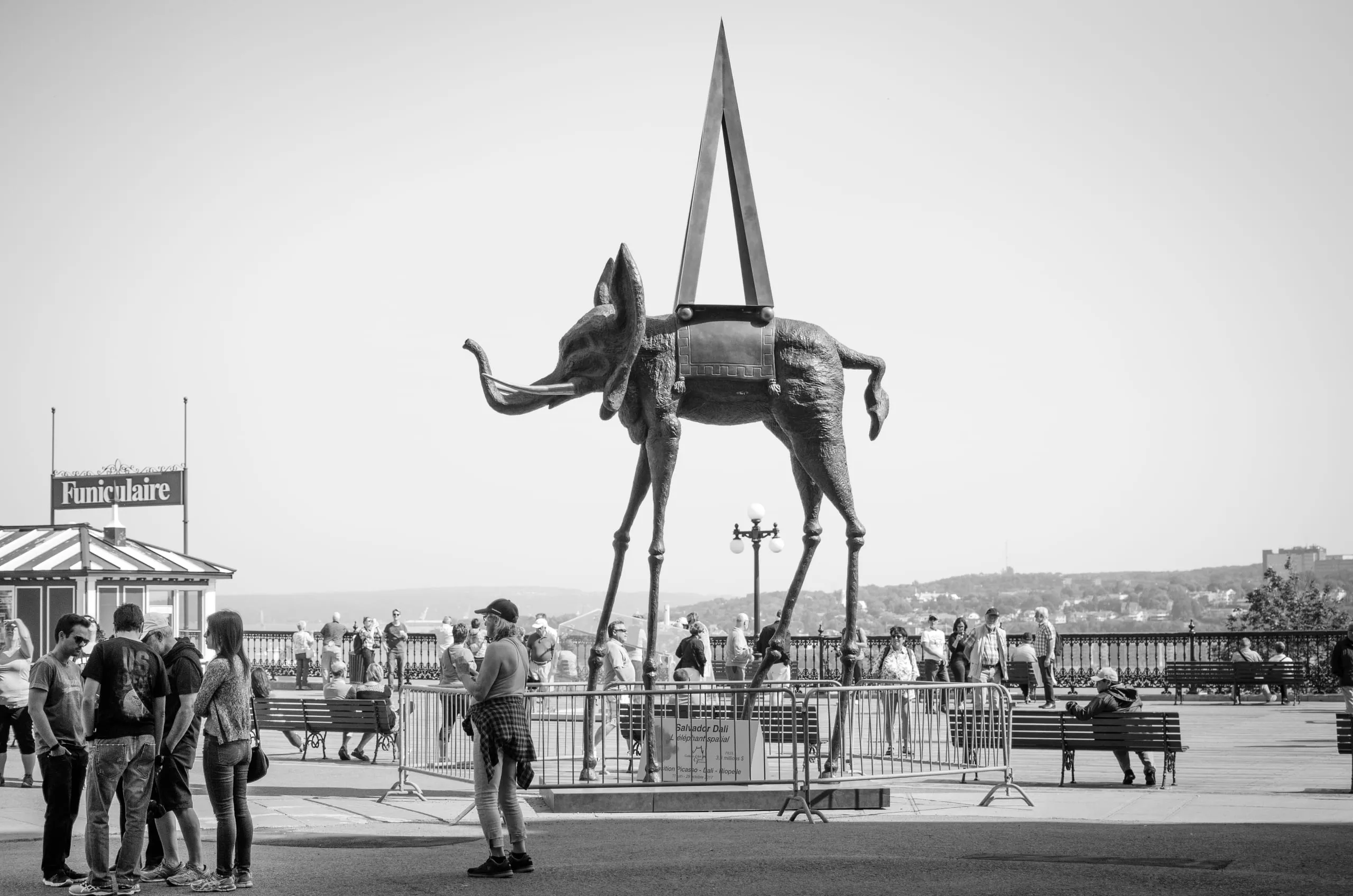 Black and white photograph of Dalí's long-legged 'Space Elephant' sculpture in a Québec City plaza