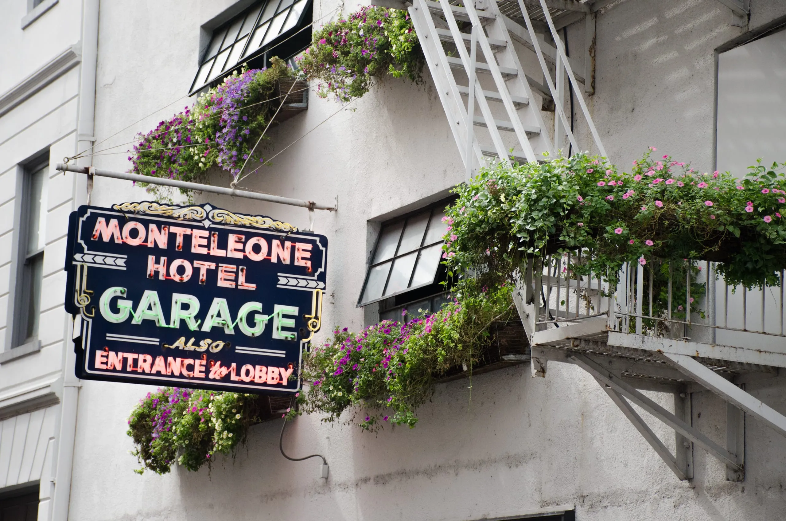 Vintage neon garage sign among iron fire escapes in the French Quarter