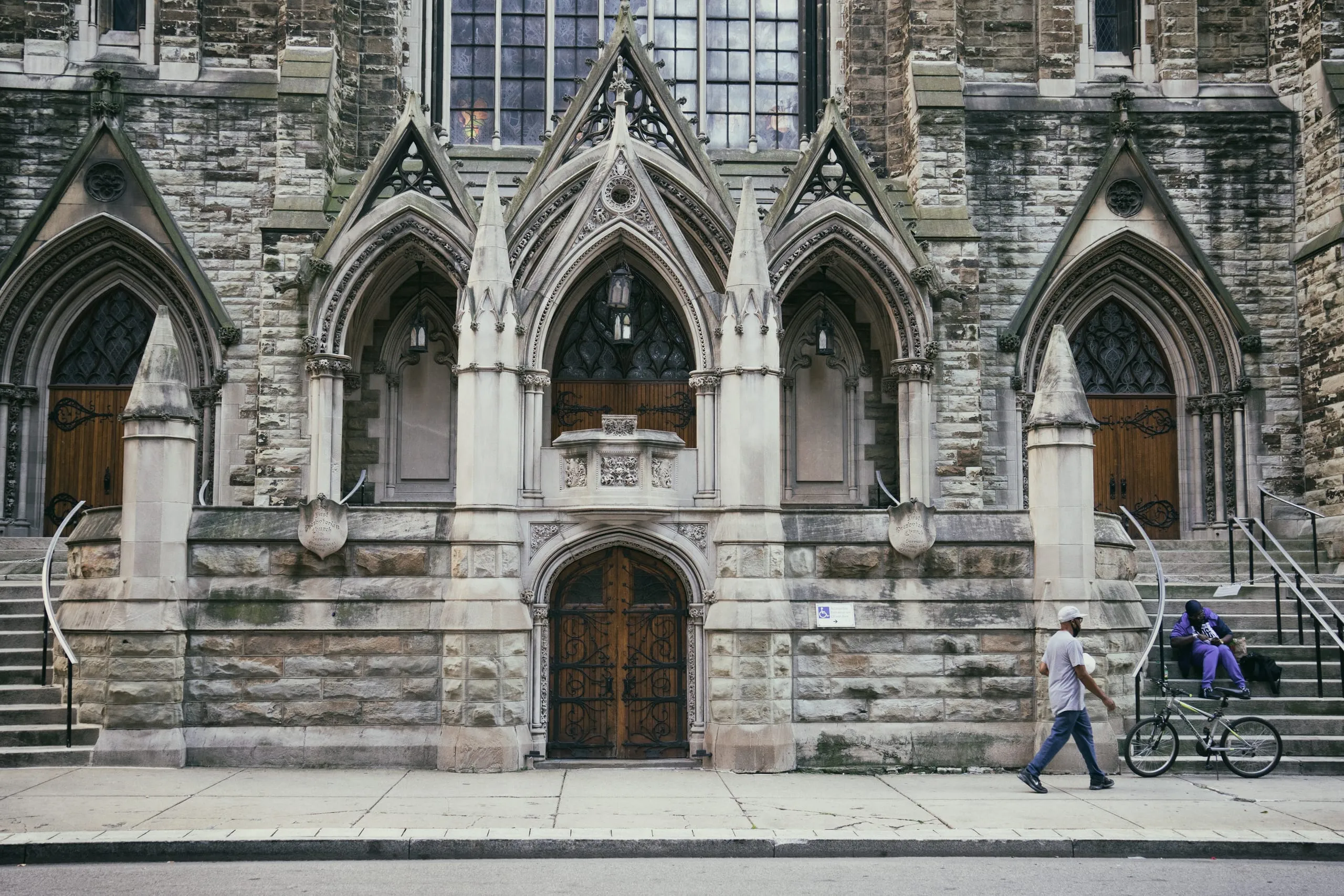 Cyclist passing a gothic stone church in Pittsburgh