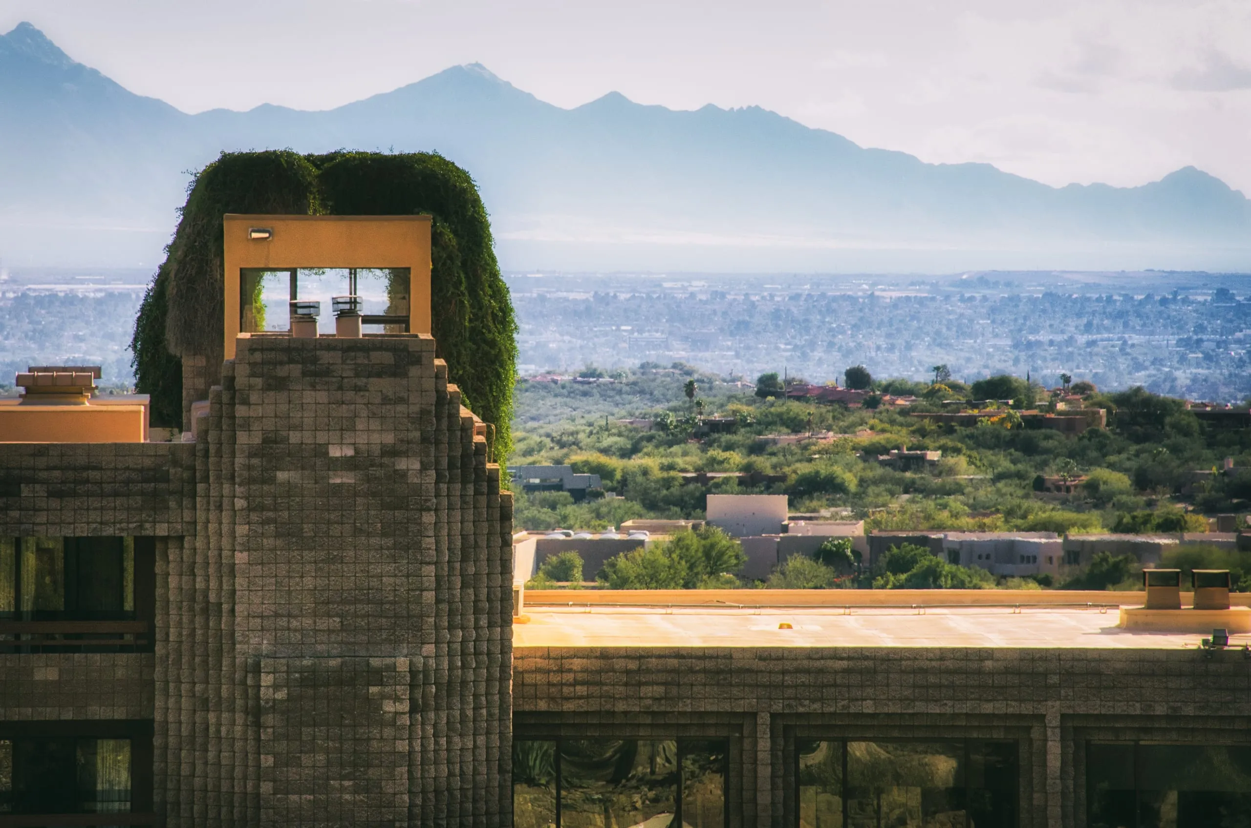 Ivy-topped concrete tower of a desert resort with mountains beyond, Arizona