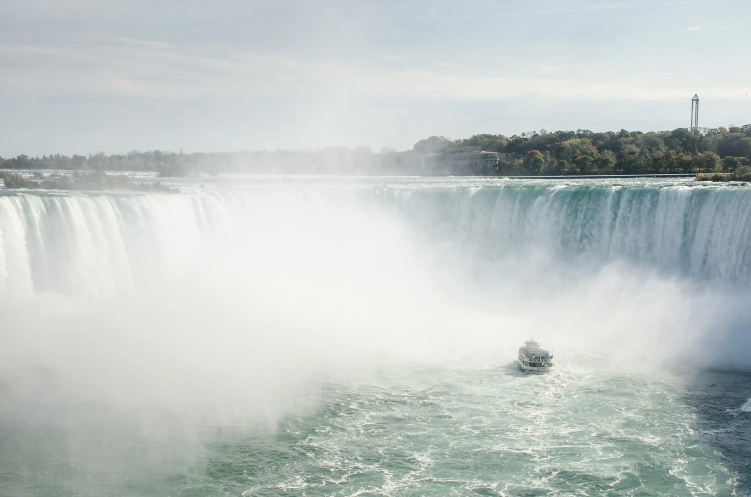 Maid of the Mist boat emerging from the mist wall beneath Horseshoe Falls, Niagara