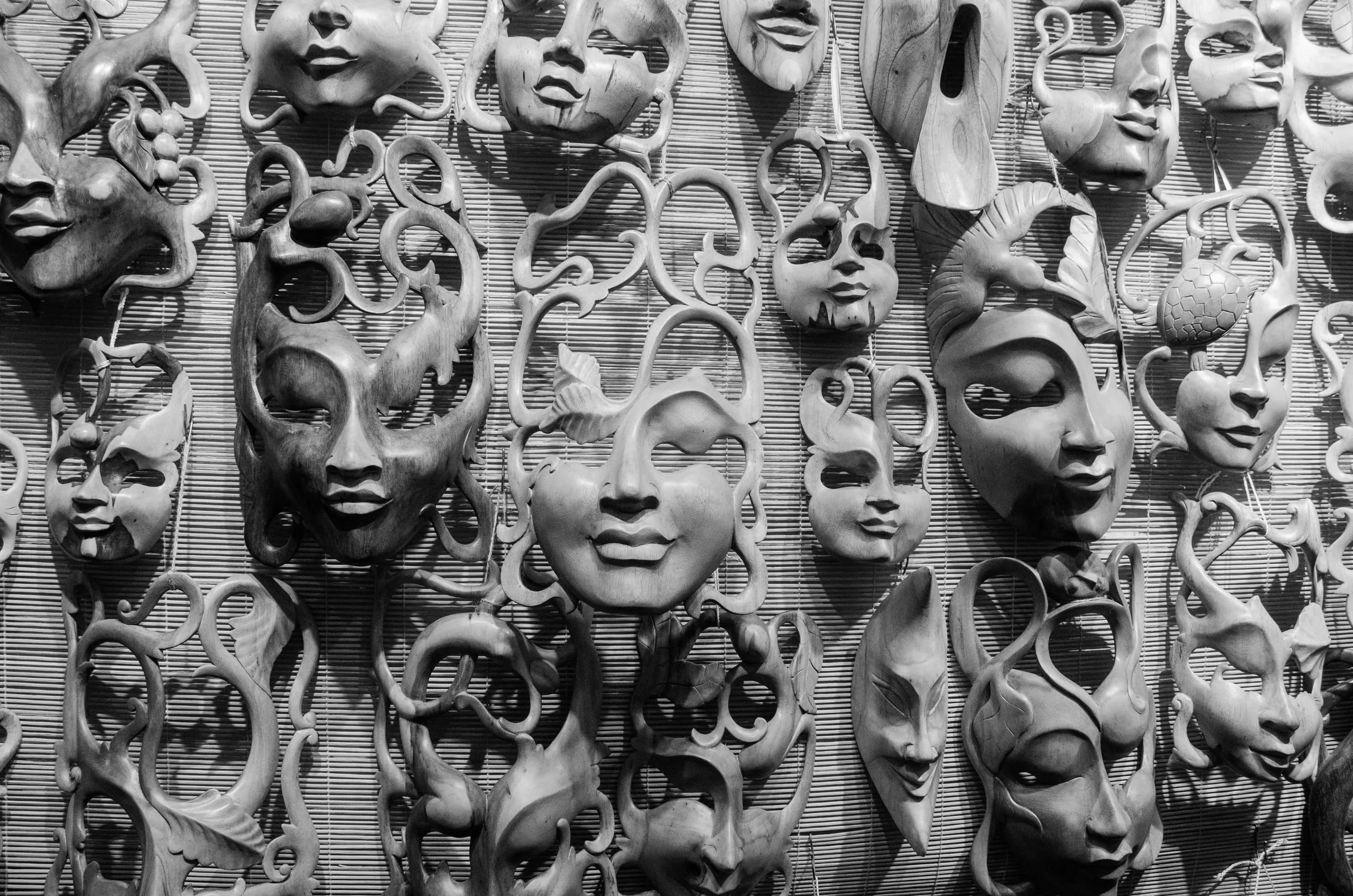 Black and white wall display of carnival masks in New Orleans