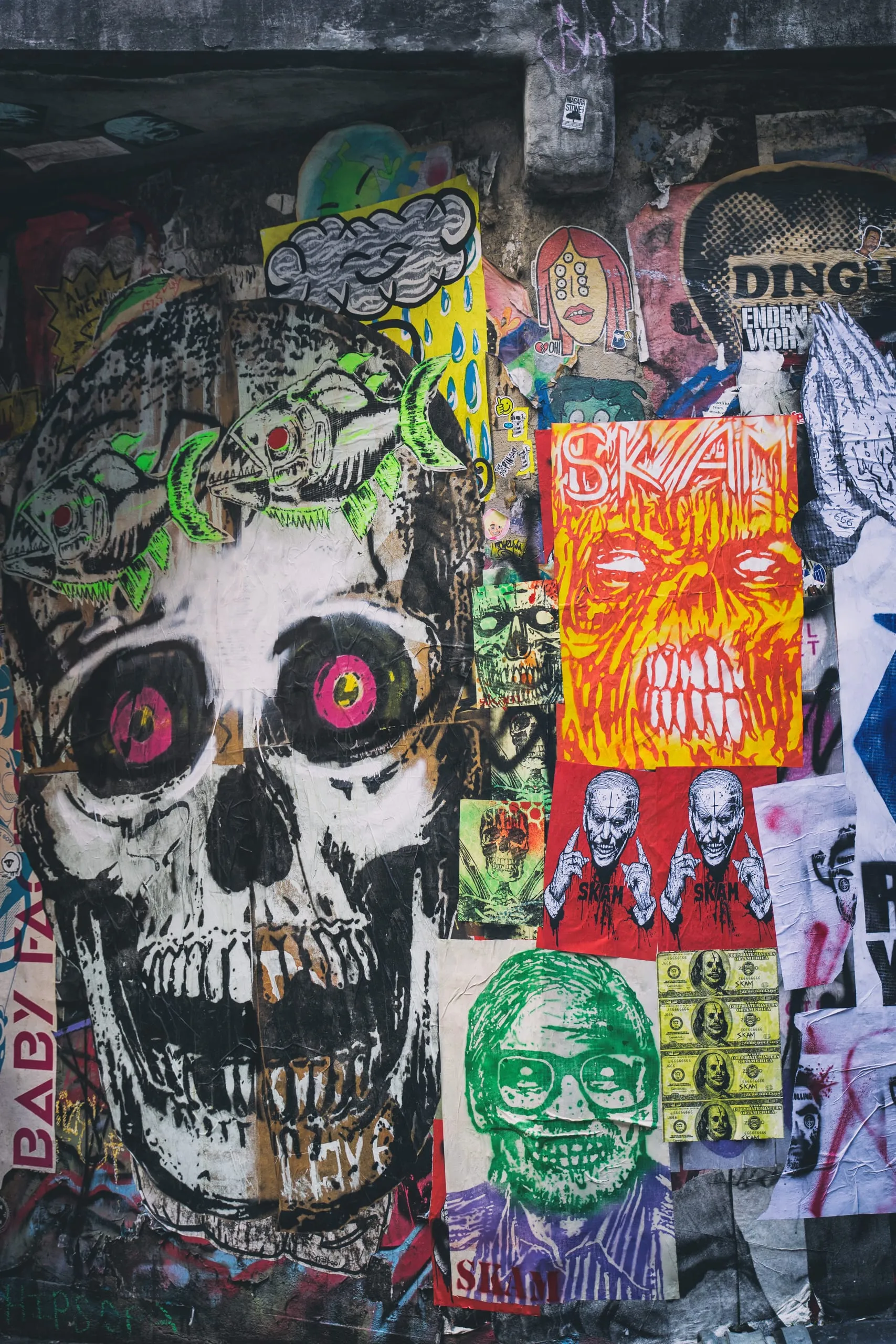 Wall collaged with skull posters and street art in Seattle's Post Alley