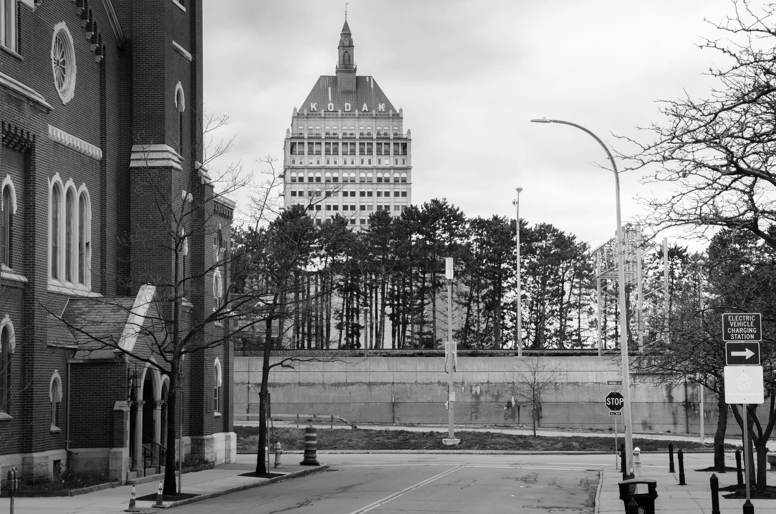 Black and white view of a brick church and the Xerox Tower over an empty downtown Rochester street