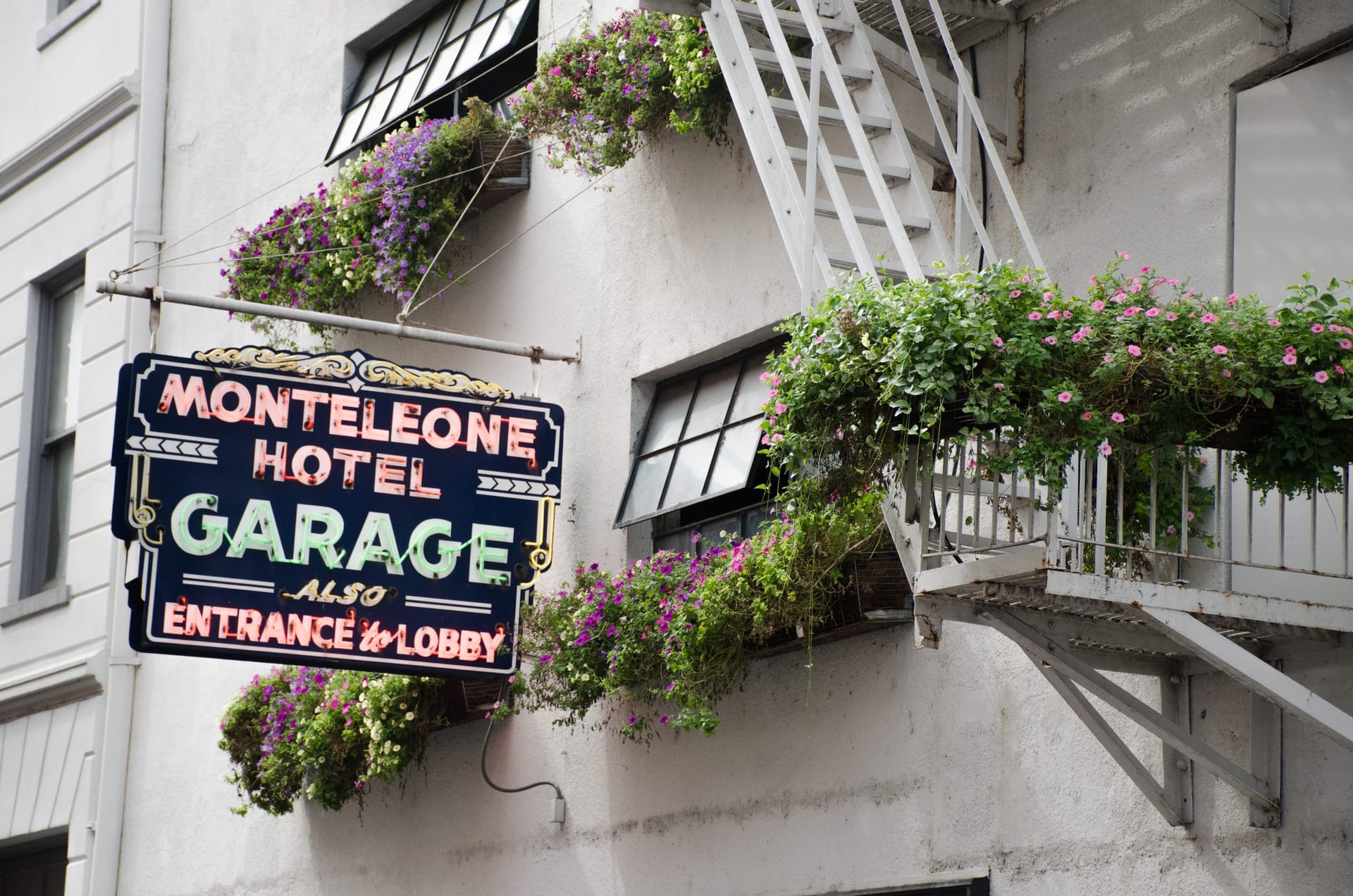 Vintage neon garage sign among iron fire escapes in the French Quarter